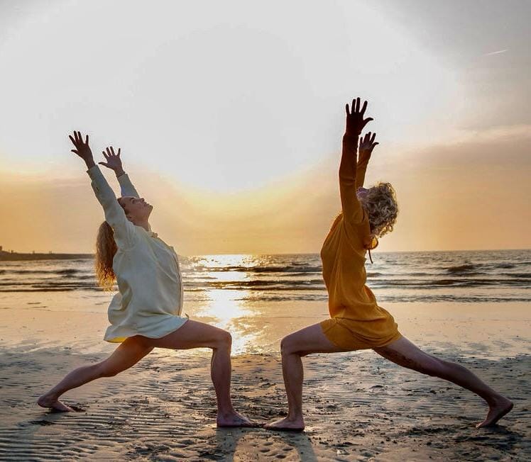 strandyoga aan de zee met zonsondergang